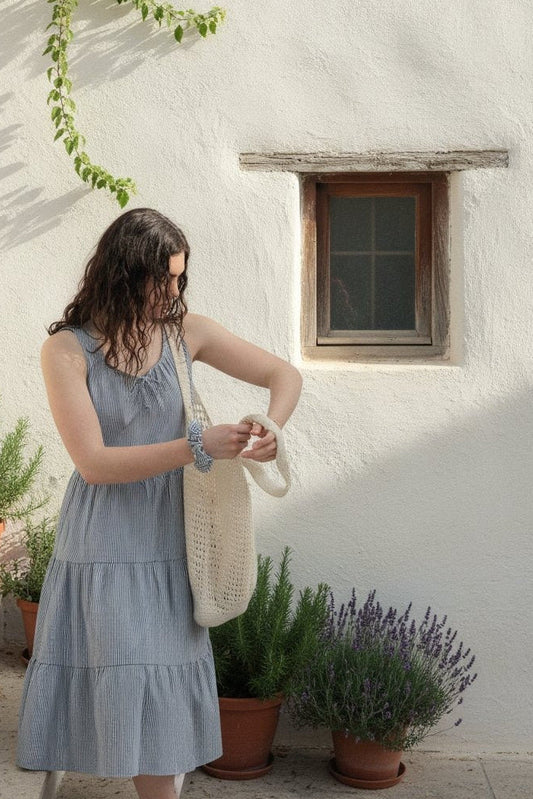 Martina Midnight navy pinstripe cotton midi dress by a whitewashed wall with climbing vine
