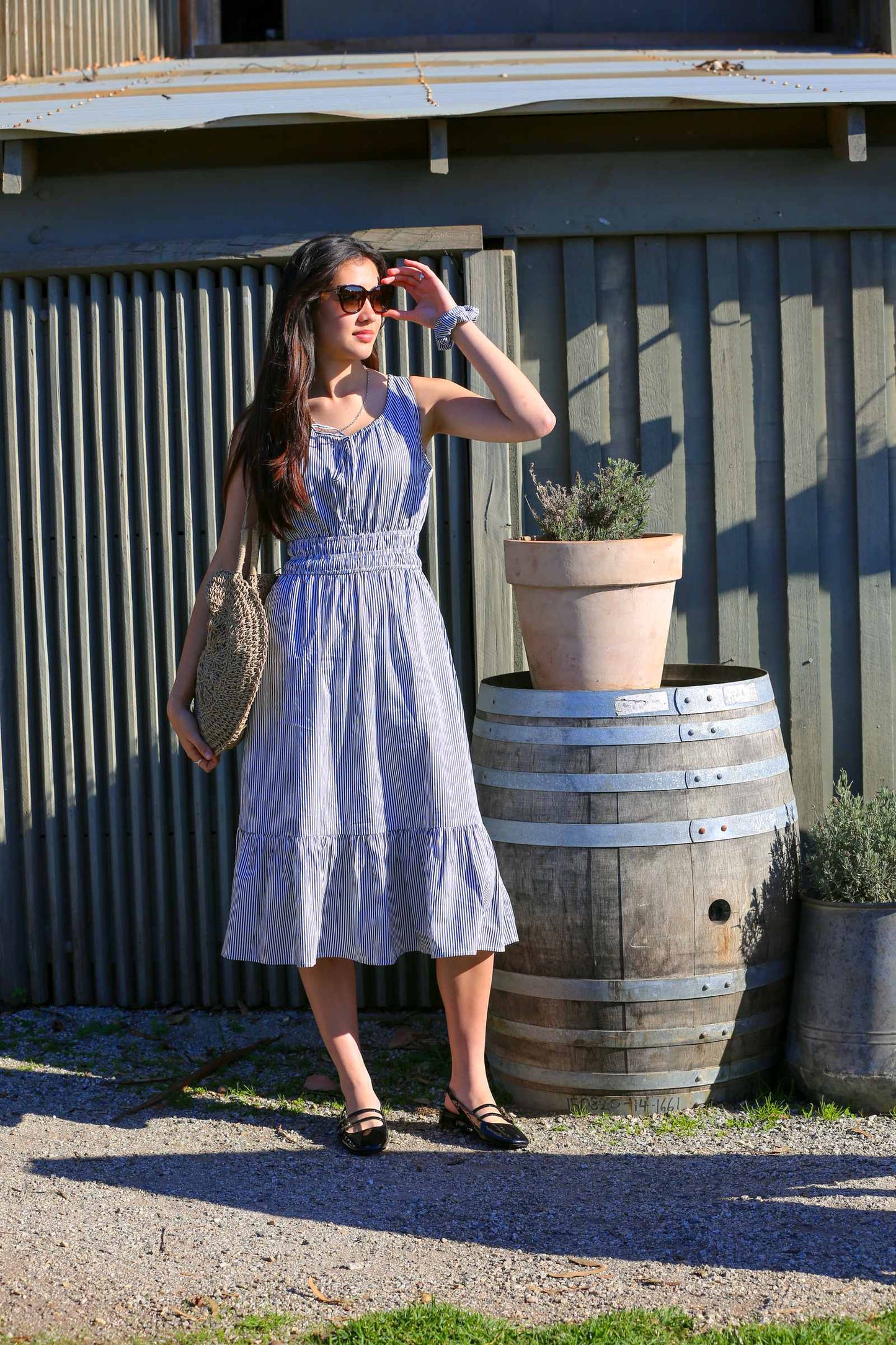 Martina Midnight lifestyle — women's sleeveless navy pinstripe cotton midi dress in natural light