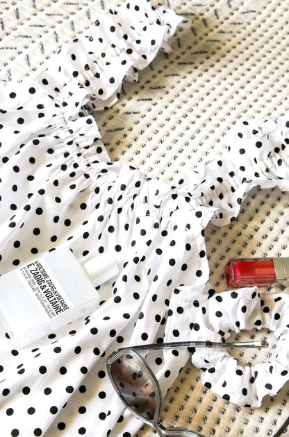 Mila Milk back view — women's white polka dot cotton mini dress with slim straps and flowing silhouette