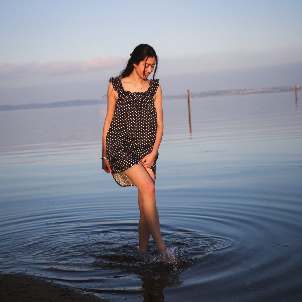 Mila Navy dress in motion at the waterline, retouched