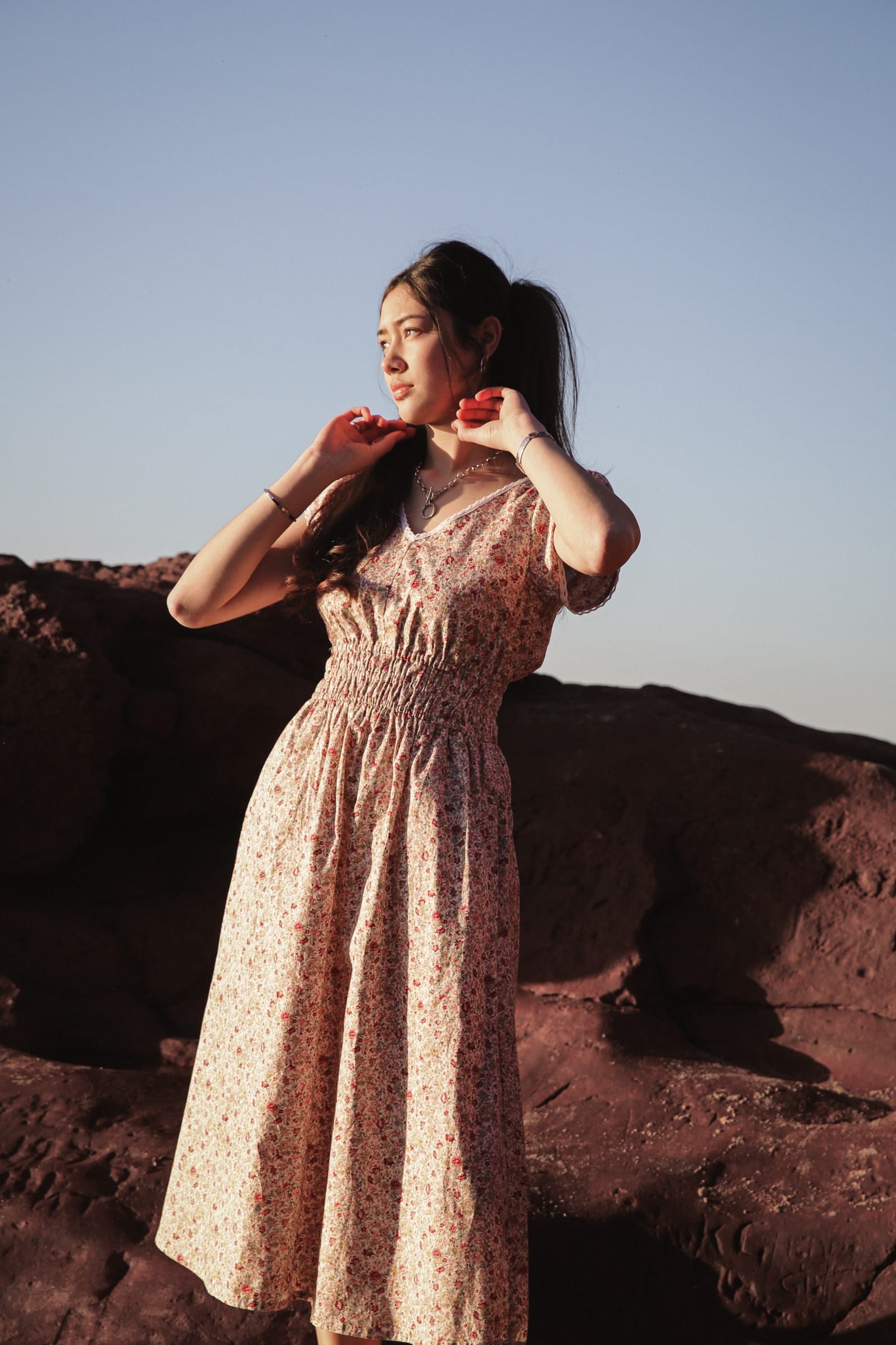 Juliet Wildflower ditsy floral dress at the cliffs, gazing toward the horizon