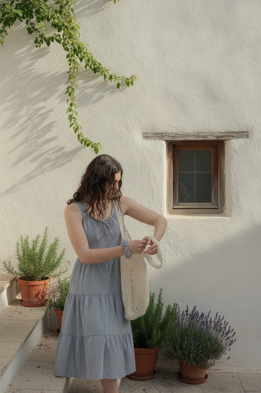 Martina Midnight navy pinstripe cotton midi dress by a whitewashed wall with climbing vine