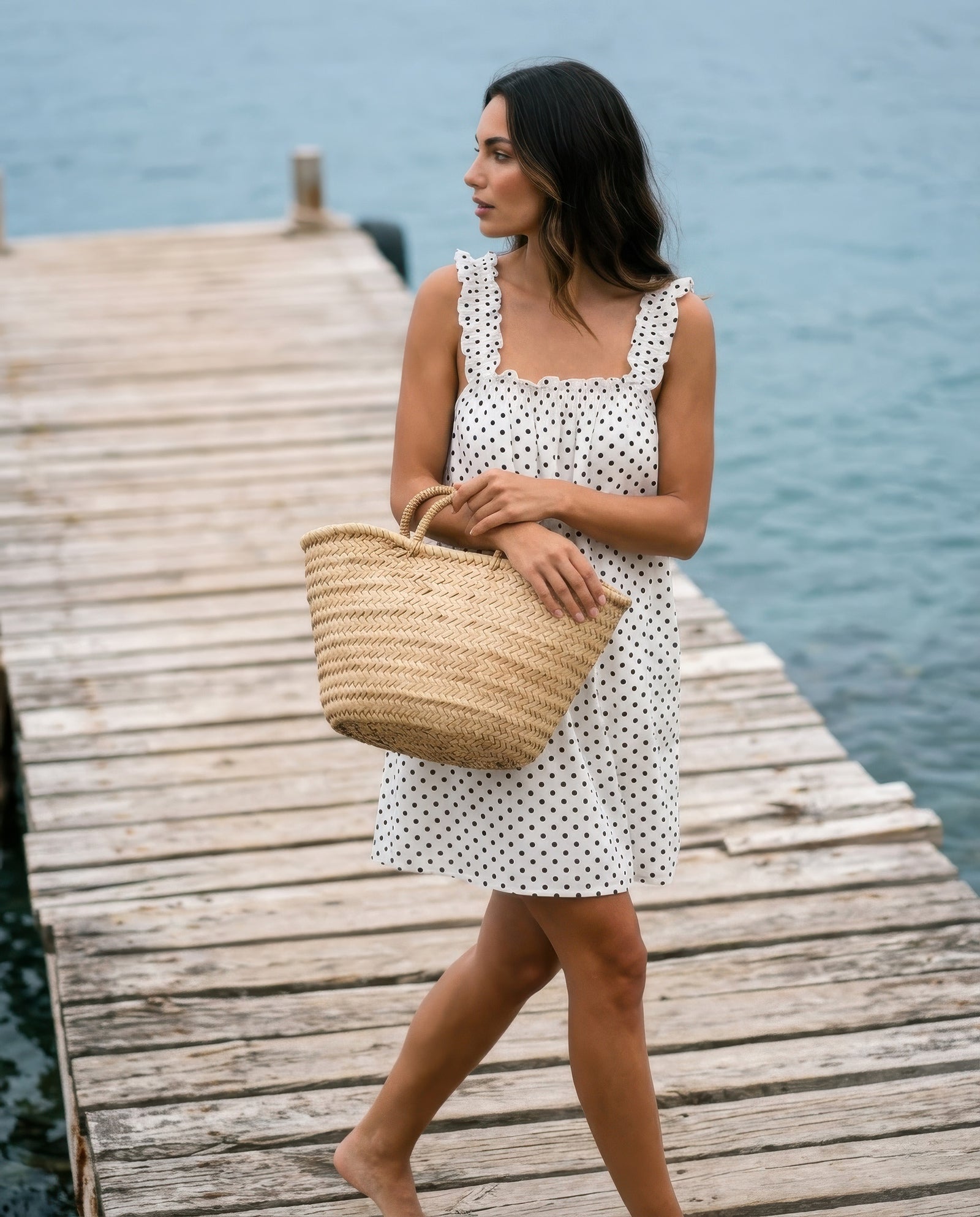 Mila White polka dot mini dress with a woven basket on a timber pier